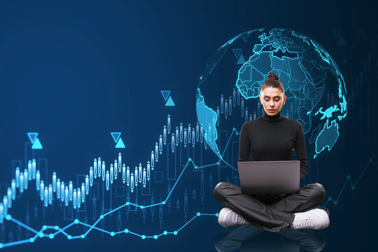 Attractive young european woman sitting on floor with laptop and creative globe hologram with growing forex chart on blue background. Global business, international stock market concept. - Powered by Adobe