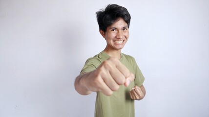 Young Asian man with kung fu boy gestures, or excited style showing his fists