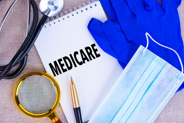 MEDICARE, the text is written on a notepad, a disposable medical mask, medical gloves, a...