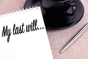 My last will, the text is written in a notebook lying on a linen canvas and a black cup.