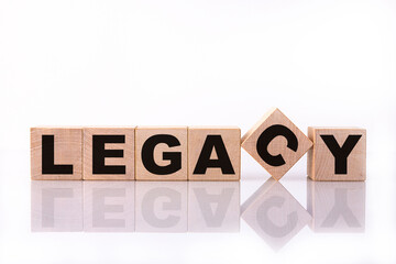 LEGACY word, text, written on wooden cubes, building blocks, over white background with reflection.