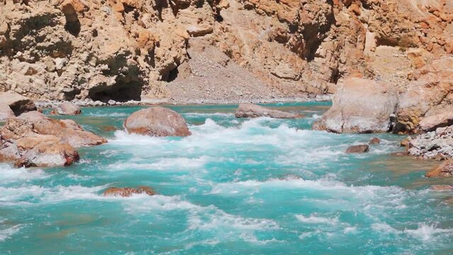 Closeup shot of blue colored Tsarap Chu river flowing in the remote areas of Zanskar as seen during the trek to Phugtal Gompa in Zanskar Valley, Ladakh, India. Blue colored river flowing in Himalayas.
