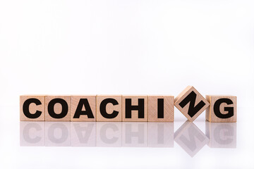 COACHING word, text, written on wooden cubes, building blocks, over white background with...