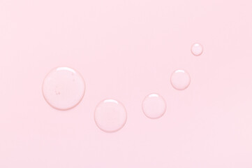 sample of cosmetic products toner serum round drops on a light pink background