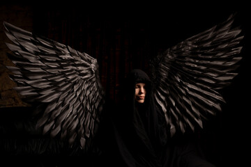 A woman with black angel wings is a reminder that we are all capable of great good and great evi
