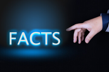 FACTS text is a word written in neon letters on a black background pointed to by a hand with a...