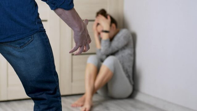 Angry husband trying to beats his wife indoors, close-up