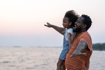 African love family father and daughter enjoying a carefree moment  strength and happiness as he lifts his young daughter, childhood, joy, leisure, parenting and outdoor activities, Father day