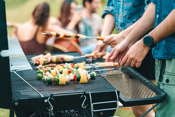 Group of diverse friend having outdoors bbq party together, camping activity lifestyle in summer,...