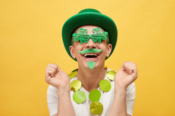 Mythology and fun celebration. Extremely happy Caucasian man wearing green leprechaun hat and...