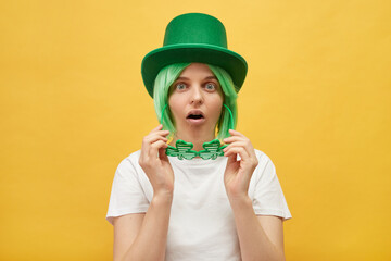 Traditional St. Patrick's Day. Shocked surprised Caucasian woman wearing green leprechaun hat...