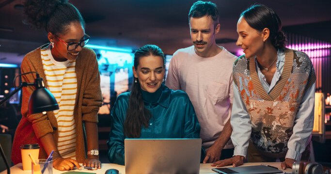 Multiethnic Group of People Working on Developing Growth Ideas Based on Data Using Laptop Computer. Energetic Teammates Brainstorming For Marketing Strategy in a Creative Office at Night