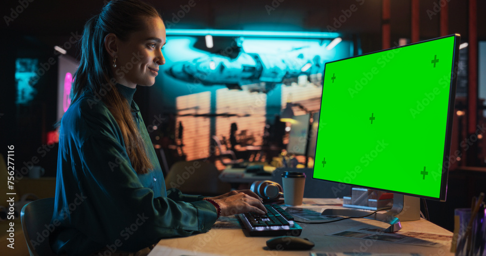 Leinwandbilder portrait of young woman sitting at her desk using desktop computer with mock-up green screen. female
