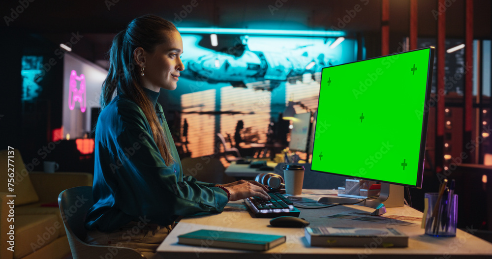 Aufkleber Portrait of Young Woman Sitting at Her Desk Using Desktop Computer with Mock-up Green Screen. Female Caucasian Specialist Working on Computer with Chroma Key Display at Creative Agency