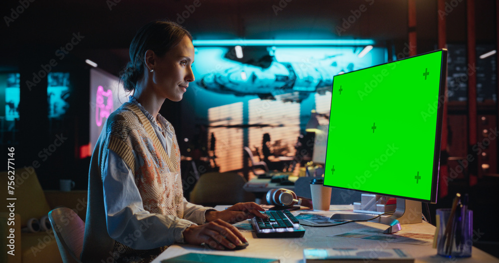 Leinwandbilder portrait of young woman sitting at her desk using desktop computer with mock-up green screen. female