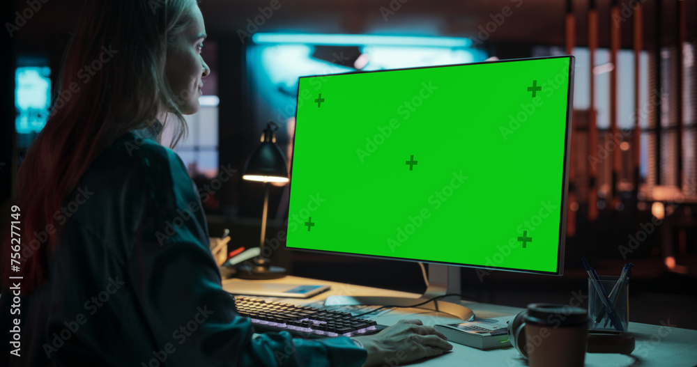 Poster Over the Shoulder: Female Caucasian Specialist Working on Computer with Chroma Key Display at Creative Agency. Young Woman Sitting at Her Desk Using Desktop Computer with Mock-up Green Screen