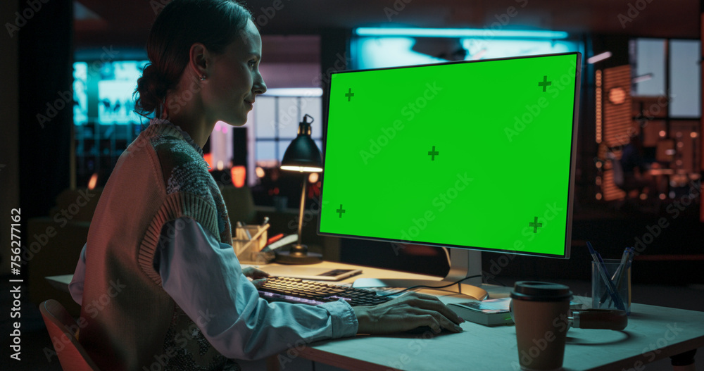 Poster over the shoulder: female caucasian specialist working on computer with chroma key display at creati