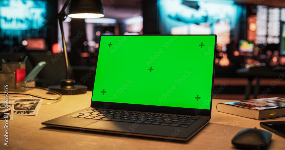 Poster laptop computer standing on a wooden desk with a green screen chromakey mock up display. creative of