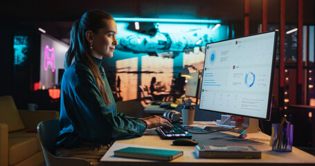 Female Talented Digital Marketing Specialist Working on Computer at Office in the Evening. Young...