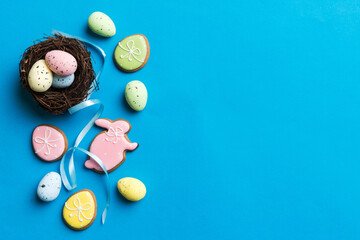 Colorful easter eggs in nest on table background with copy space top view