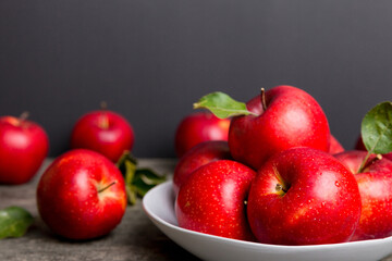 juicy red apples in a bowl or plate on the table top view. Copy space