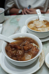 Close up Beef tendon soup and Shrimp Wontons served in white ceramic bowl