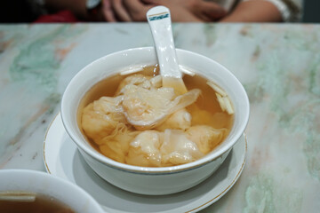 Close up Shrimp Wontons soup served in white ceramic bowl