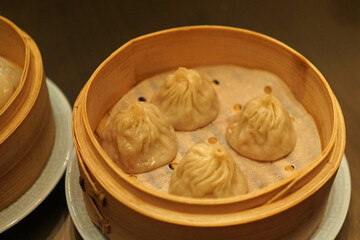 Close up 'Xiao Long Bao' Chinese Dim Sum, broth-filled Shanghainese steamed pork dumplings served in wooden basket container