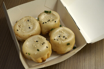 Close up take away paper box of Shanghai Pan fried Buns, dumplings stuffed with minced pork or shrimp