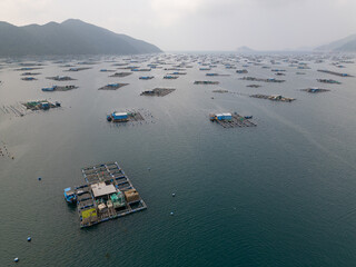 Aerial drone shot of floating aquaculture fish farm village in Vung Ro Bay on Vietnam's South China Sea coast