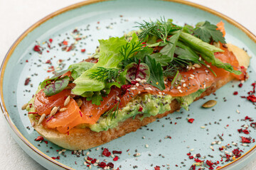 Breakfast toast with salmon and avocado on plate