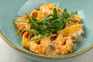 Closeup on portion of italian pappardelle pasta with shrimp