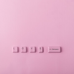 Top view of word love made of keyboard keys isolated on pink background. Complicated relationships,...