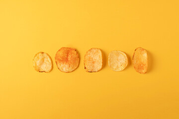 Potato chips on yellow background. Flat lay, top view.