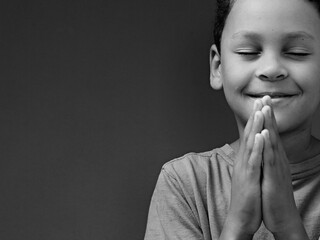 boy praying to God with hands together on white background stock photo	