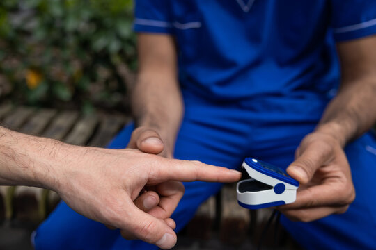 Close up of doctors hands measuring patients pulse with pulsometer