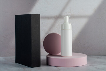 Plastic white tube for cream or lotion. Skin care or sunscreen cosmetic with stylish props on white background.