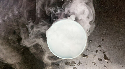 Image effect of smoke produced by putting water in dry ice in plastic bowl on black granit floor. - 756301960