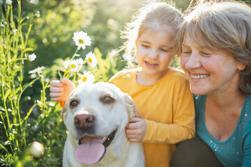 Gray-haired grandmother and cute little granddaughter are walking their dogs together in the park