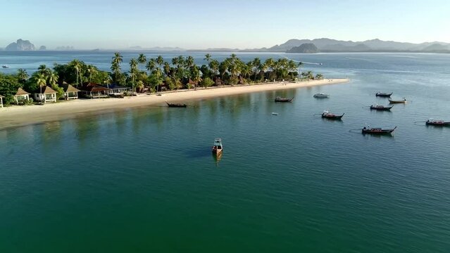 Pull-out drone shot of local boats at Siwalai beach on Koh Mook tropical island in Andaman sea, Trang, Thailand