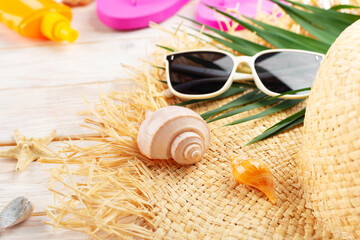 Vacation travel planning background of palm leaves, straw hat, sunglasses on white planks with copy-space