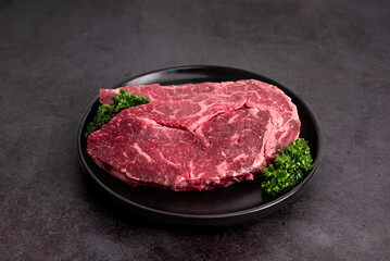 Plated beef on a dish against a black background