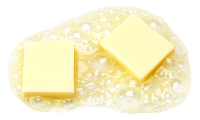 Two pieces of butter melting isolated