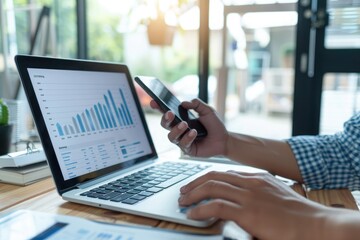 Businessman analyzing investment charts with laptop and mobile phone. Investment and trading concept