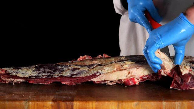 il macellaio taglia la bistecca con il coltello affilato.
in macelleria: Primo piano della carne rossa da cuocere alla griglia.