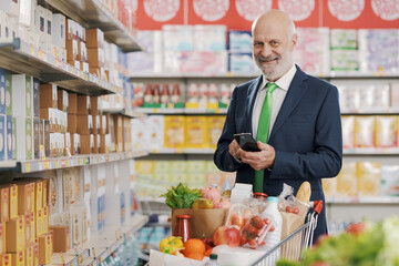Businessman using a smartphone at the supermarket