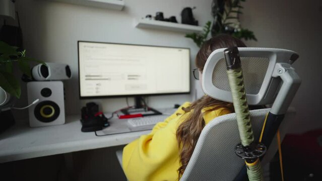 The girl is a modern neuro artist who compiles and writes a prompt for the artificial intelligence program. The AI program gradually draws an image on the screen according to the task.