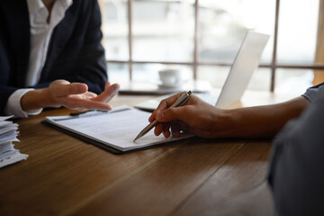 Closeup lawyer or insurance agent pointing at contract showing male client where to signature sign