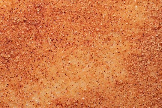 Granulated sugar and ground cinnamon close-up on the surface of the dough, macro photo