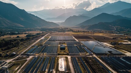 Early morning light bathes a solar farm located in a valley surrounded by mountains, showcasing the harmony of technology and nature. - obrazy, fototapety, plakaty